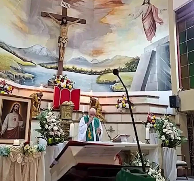 Cruz de madeira atrás do altar durante missa transmitida ao vivo